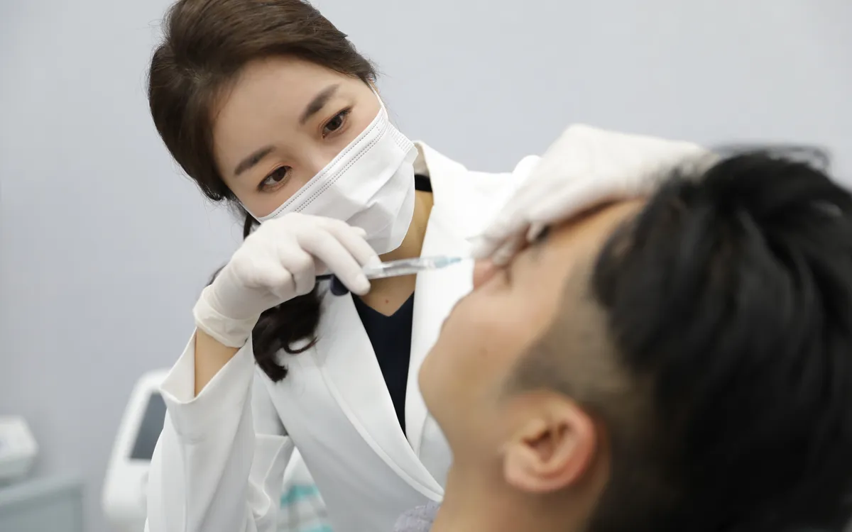 Doctor placing filler in a patient's face with a thin cannula at Time Return Clinic in Seoul